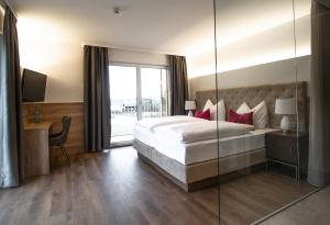 ein Schlafzimmer mit einem Bett und einer Glaswand in der Unterkunft Hotel Weiß in Munderfing + 73 Fotos