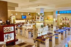 ein Restaurant mit weißen Tischen und Stühlen und einer Bar in der Unterkunft Nidimos Hotel in Delphi