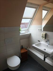 a bathroom with a toilet and a sink and a window at Hotel Zum Roten Tore in Lüneburg +27 photos