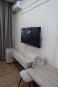 a room with a tv on a wall with a chair at Кочевник in Semey