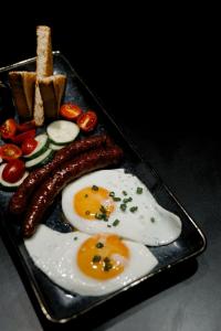 a tray with two eggs and sausage and bread at Кочевник in Semey