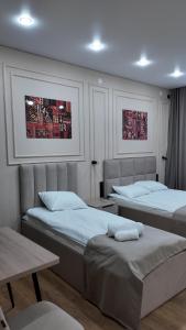 a bedroom with two beds and a table at Кочевник in Semey