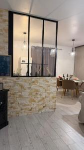 a living room with a stone wall and a table at Le Green d'Apigné in Le Rheu
