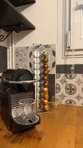 a toaster oven sitting on a wooden table with glasses at Le Green d'Apigné in Le Rheu +7 photos