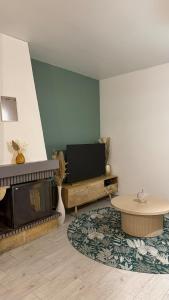 a living room with a fireplace and a television at Le Green d'Apigné in Le Rheu