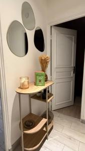 a table with two mirrors on a wall at Le Green d'Apigné in Le Rheu