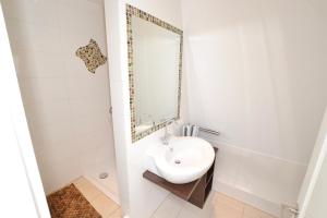 a bathroom with a sink and a mirror at Syltstyle 12 in Tinnum