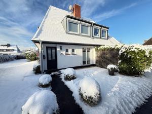 a white house with snow on the ground at Syltstyle 12 in Tinnum