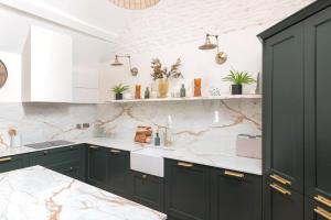 a kitchen with black cabinets and marble counter tops at The Foaling Box at Lanhill in Oakhill +28 photos