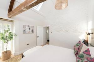 a white bedroom with a bed and a window at The Foaling Box at Lanhill in Oakhill