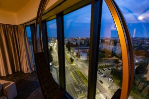 a room with a window with a view of a city at Kaleo apartments - Hanza Tower in Szczecin