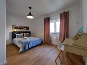 a bedroom with a bed and a desk and a piano at Praia Dona Ana - Bedrooms in shared apartment in Lagos +9 photos
