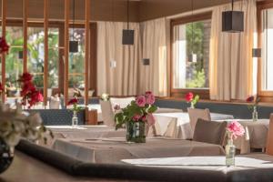 a dining room with tables and chairs with flowers on them at Pension Sonnheim in Gargazzone