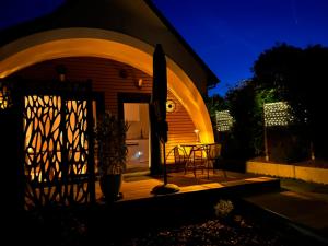 a house with a gate and a patio at night at Ecolodge "Les Treilles Monet" Gîte insolite en Champagne à proximité d'Epernay in CumiÃ¨res +12 photos