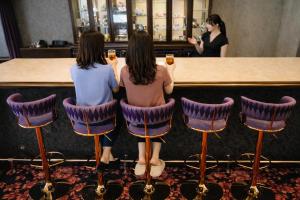 two women sitting in chairs at a bar at Rose hakodate in Hakodate
