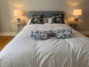 a white bed with three pillows on top of it at Murrayfield Gem in Edinburgh