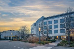 an office building with a parking lot in front of it at Spark by Hilton Lyon Eurexpo in Genas
