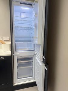 an empty refrigerator with its door open in a kitchen at Murrayfield Gem in Edinburgh +11 photos
