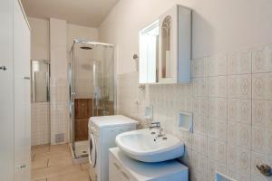 a bathroom with a sink and a washing machine at Villa Ferri in Peschiera del Garda +42 photos