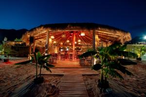 a restaurant on the beach at night at Domi Drymades in Dhërmi