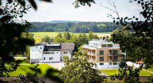 ein großes weißes Gebäude mitten auf einem Feld in der Unterkunft Hotel Weiß in Munderfing