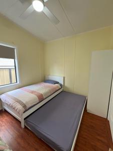 a bedroom with a bed with a ceiling fan at Blacksmiths Beach Shack in Blacksmiths