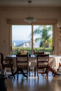 a dining room with a table and chairs and a large window at ROSE VILLA - 3 BED POOL in Episkopi Limassol