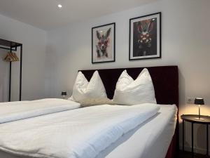 a bedroom with two beds with white pillows at Apartment Ramazotti - inklusive Eintritt in die Alpentherme in Bad Hofgastein