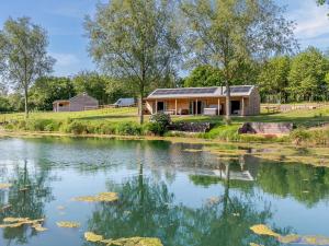 a house with a pond in front of it at 3 Bed in Cullompton oc-96118 in Willand