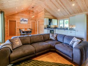 a large brown couch in a room with a kitchen at 3 Bed in Cullompton oc-96118 in Willand