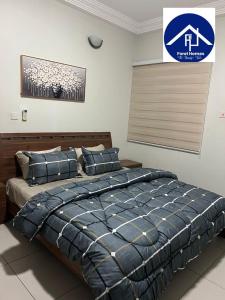a bedroom with a bed with a blue comforter at FOREL RESIDENCE Jc in Accra