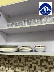 a shelf with plates and bowls on it at FOREL RESIDENCE Jc in Accra