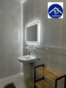 a bathroom with a sink and a tv on the wall at FOREL RESIDENCE Jc in Accra