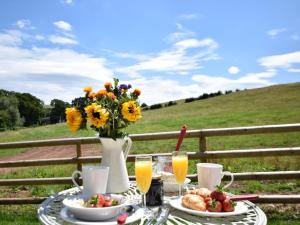 a table with a vase of flowers and a plate of food at 1 Bed in Hereford oc-78641 in Callow