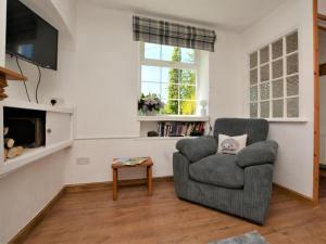 a living room with a chair and a television at 2 Bed in High Peak oc-57871 in Hayfield