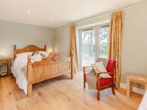 a bedroom with a bed and a chair and a window at 3 Bed in Whitchurch oc-88915 in Whixall