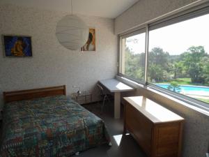 a bedroom with a bed and a desk and a window at Mahero in Nîmes +19 photos