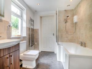 a bathroom with a tub and a toilet and a sink at 2 Bed in Llangammarch Wells oc-bn059 in Garth