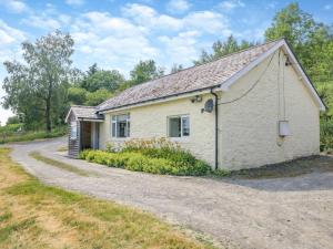 a white cottage with a gravel road at 2 Bed in Llangammarch Wells oc-bn059 in Garth