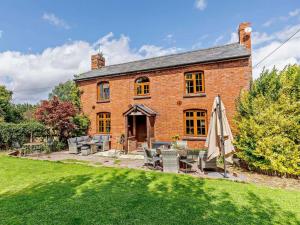 an exterior view of a brick house with an umbrella at 4 Bed in Hereford oc-44213 in Hereford