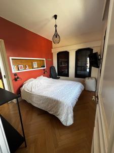 a bedroom with a large bed with orange walls at Apartment with terrace Mérignac in Mérignac