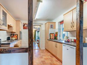 a kitchen with wooden cabinets and a counter top at 1 Bed in Abergavenny oc-52882 in Gilwern
