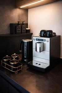 a kitchen counter with a coffee maker and a coffee pot at Modern Royal Suite in Hirschaid
