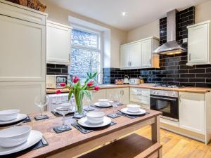 a kitchen with a table with plates and flowers on it at 3 Bed in Buxton oc-77955 in Tideswell