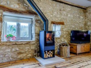 a living room with a fireplace in a stone wall at 2 Bed in Matlock oc-83435 in Bonsall
