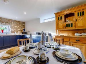 a kitchen with a table with plates and dishes on it at 2 Bed in Matlock oc-83435 in Bonsall