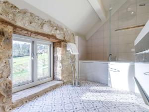 a bathroom with a stone wall and a window at 2 Bed in Matlock oc-83435 in Bonsall +16 photos