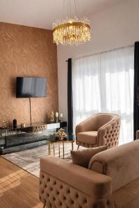 a living room with a couch and chairs and a chandelier at Modern Royal Suite in Hirschaid