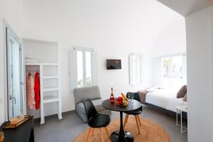 a white room with a bed and a table and a bed at Stay Lux Suites in Karterados