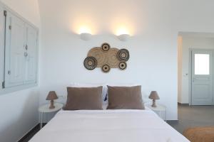 a bedroom with a large white bed with two tables at Stay Lux Suites in Karterados +50 photos